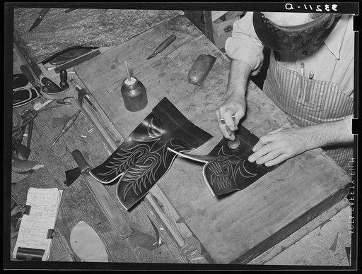 Tamping glued leather together after the heel section of uppers has been attached to stitched section of boot. Bootmaking shop, Alpine, Texas