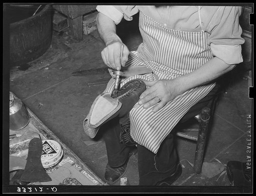 Applying glue to cement outer sole to the inner sole of the boot. Cowboy boot shop, Alpine, Texas
