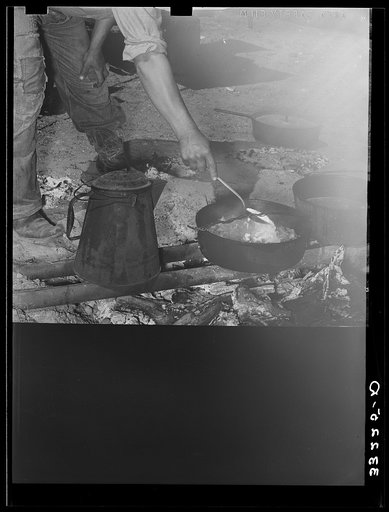 Untitled photo, possibly related to: Camp cook at work with chuckwagon in background. Cattle ranch near Marfa, Texas