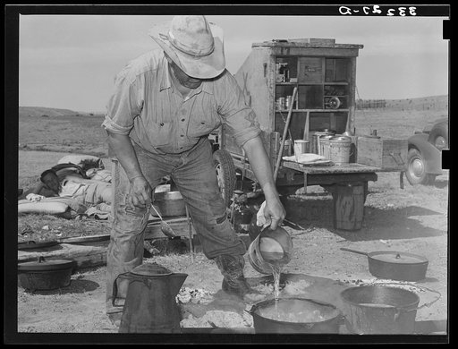 Camp cook at work with chuckwagon in background. Cattle ranch near Marfa, Texas