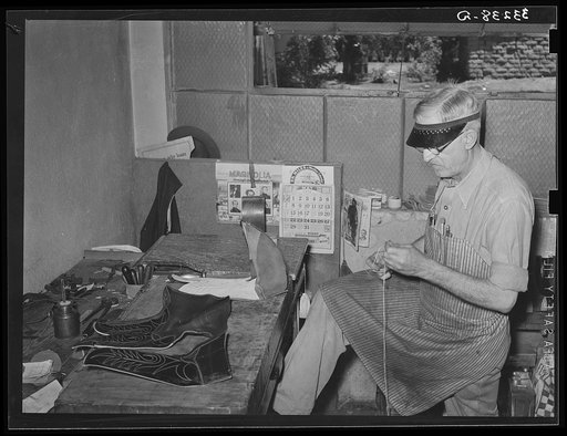 Threading needle to sew uppers of boots together. Boot shop, Alpine, Texas
