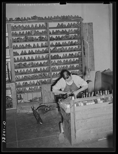 Bootmaker in his shop with lasts forming background. Cowboy boot shop, Alpine, Texas