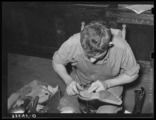 Building up the heel of cowboy boots with pieces of leather which are held together by wooden pegs. Cowboy boot shop, Alpine, Texas