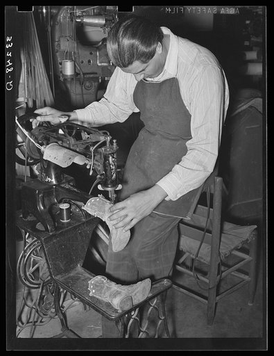 Repairing a pair of child's cowboy boots in saddle shop. Alpine, Texas