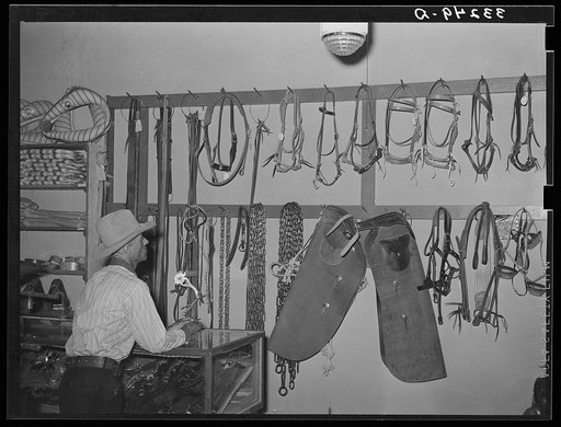 Cowboy looking at ranch supplies. Saddle shop, Alpine, Texas