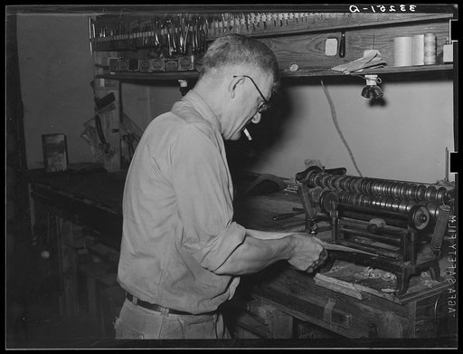 Skiving leather in saddle shop. Alpine, Texas