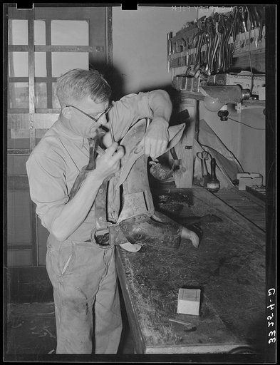 Repairing a saddle. Saddle shop, Alpine, Texas