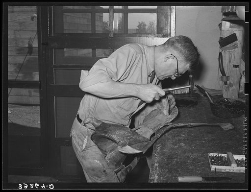 Repairing saddle. Saddle shop, Alpine, Texas