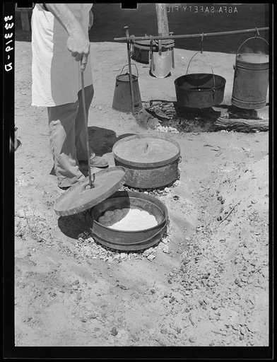 Cook of SMS Ranch making bread in Dutch oven. Near Spur, Texas