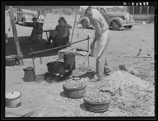 Cook of SMS Ranch making bread in front of chuck wagon. Ranch near Spur, Texas