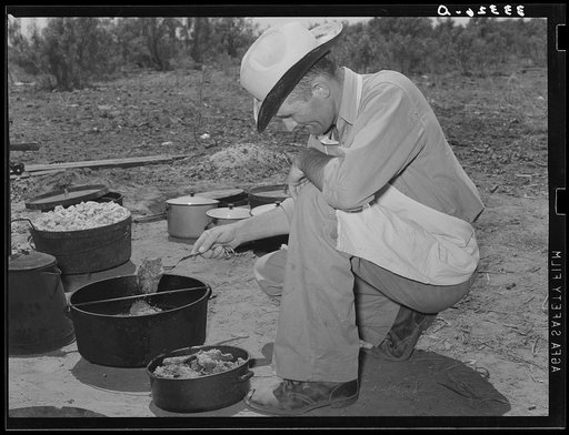 Cook of the SMS Ranch frying meat at chuck wagon on ranch near Spur, Texas