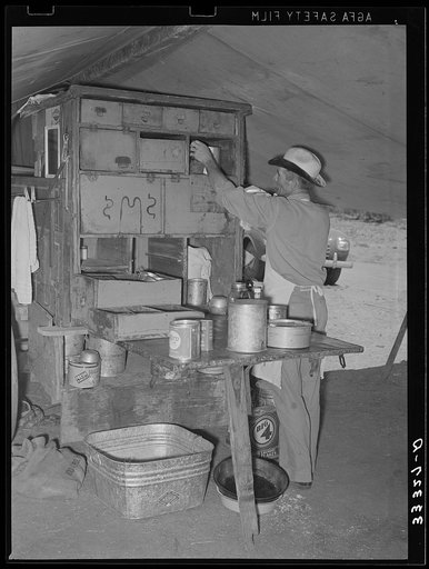 Cook of the SMS Ranch in front of the covered end of the chuck wagon. Ranch near Spur, Texas