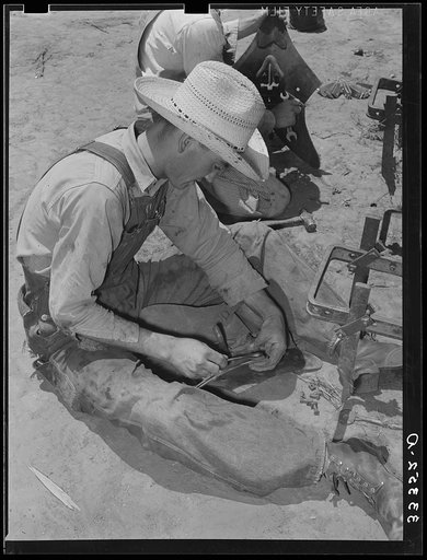 Untitled photo, possibly related to: Day laborer adjusting plow points on tractor-drawn planter, farm near Ralls, Texas