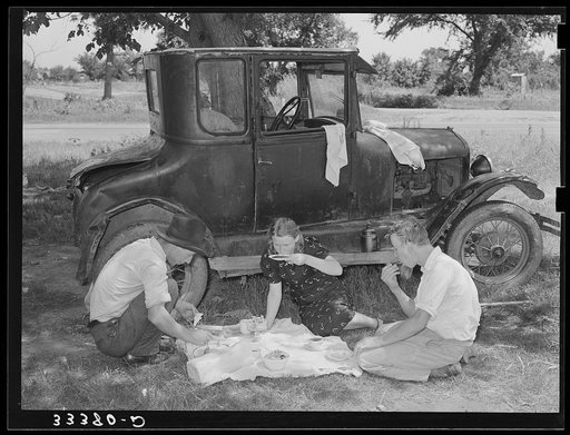 Migrant workers eating dinner by the side of their car while they are camped near Prague, Oklahoma. Lincoln County