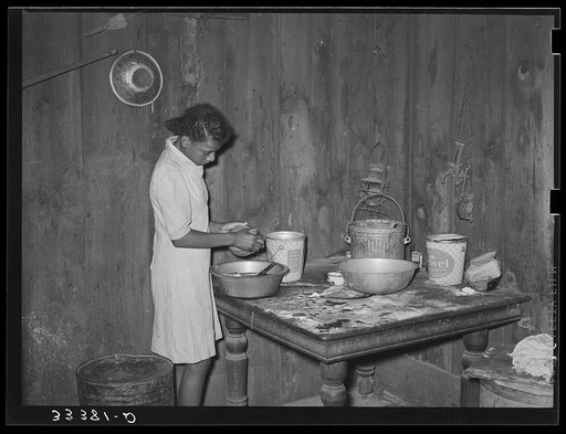 Daughter of Negro agricultural day laborer washing dishes in her home in Muskogee County, Oklahoma