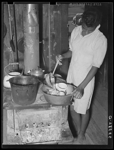 Daughter of Negro agricultural day laborer washing dishes in her home in Muskogee County, Oklahoma