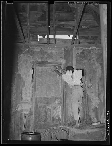 Untitled photo, possibly related to: Room in house of Negro agricultural day laborer. Note hole in roof and boarded-up door. Muskogee County, Oklahoma