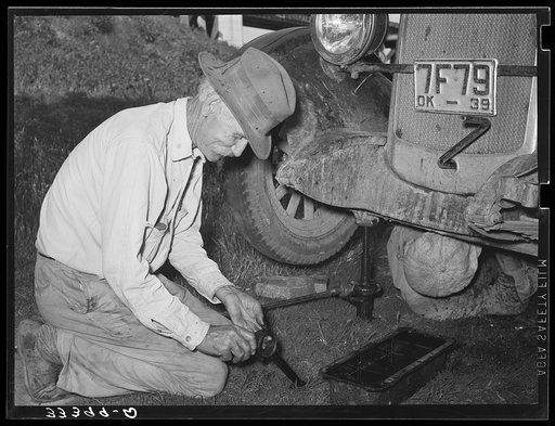 Father of migrant steeple-jack putting bolts in connecting rod while camped near Prague, Oklahoma. Lincoln County