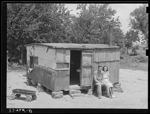 WPA (Works Progress/Work Projects Administration) worker and his wife sitting in front of their shack home on the Arkansas River near Webbers Falls, Oklahoma. This man said that last year he thought maybe he would be a little better off when he got the WPA work and had a small amount of cash coming 