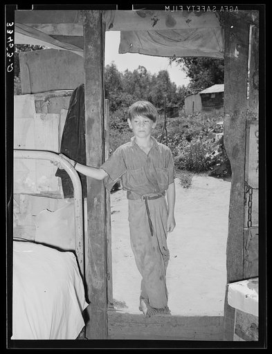 Son of day laborer in doorway of camp home in Arkansas River bottom at Webbers Falls. Muskogee County, Oklahoma