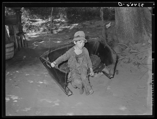 Son of WPA (Works Progress Administration/Work Projects Administration) worker swinging. The father is a former tenant farmer, now on WPA. These are potential and probable migrants. Webbers Falls, Oklahoma