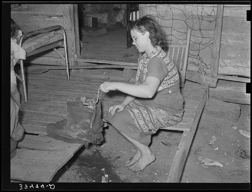 Wife of tenant farmer freezing ice cream on porch of her home near Warner, Oklahoma