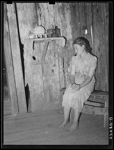 Agricultural day laborer sitting in corner of one room of her two-room shack home near Webbers Falls, Oklahoma. This girl had never gone to school although she appeared to be about seventeen years of age. Her attitude was one of complete hopelessness. The entire family was demoralized in every way