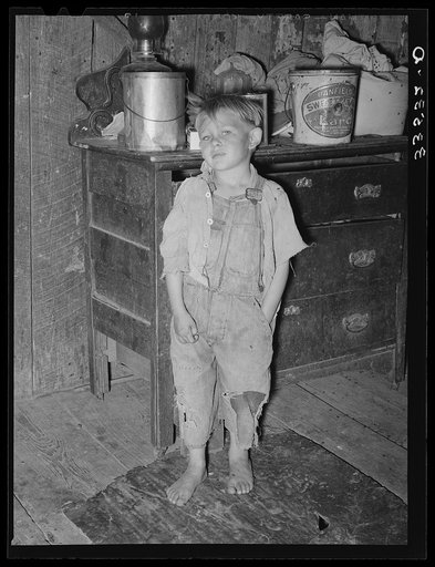 Child of white tenant farmer in kitchen of his home. McIntosh County, Oklahoma. Notice the pail of lard