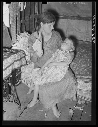 Wife and daughter of agricultural day laborer near Tullahassee, Oklahoma. She is fanning flies away from sick child. Wagoner County