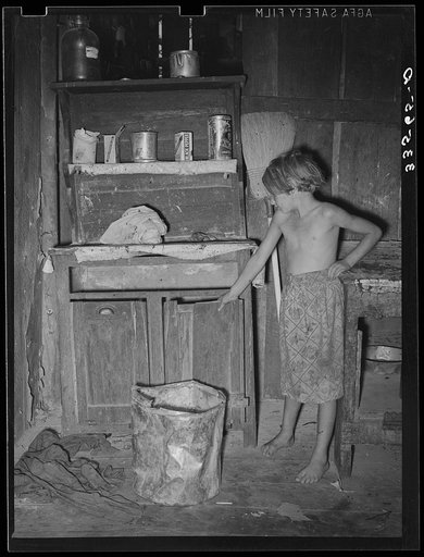 Daughter of day laborer in front of kitchen cabinet. McIntosh County, Oklahoma