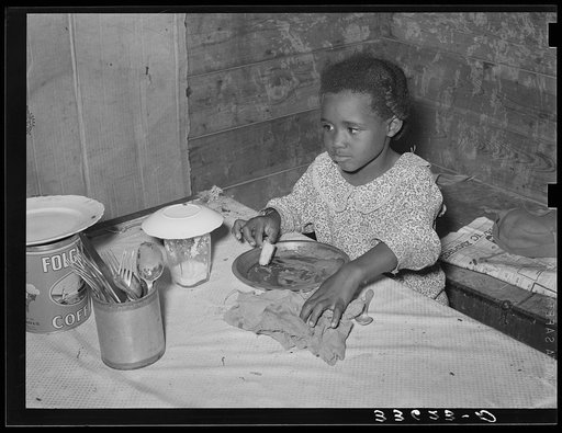 Daughter of Negro tenant farmer eating bread and flour gravy for dinner. Wagoner County, Oklahoma