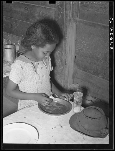 Daughter of Negro tenant farmer eating bread and flour gravy for dinner. Wagoner County, Oklahoma