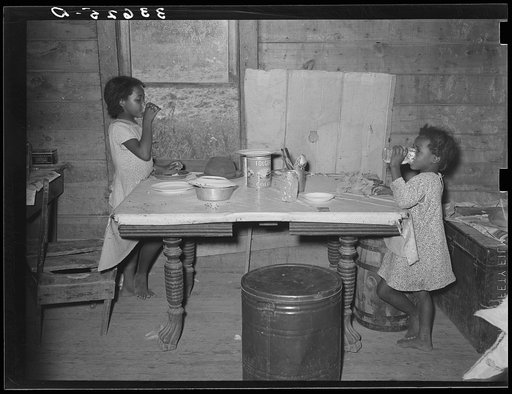 Children of Negro tenant farmer eating lunch. Lunch consisted of bread and flour gravy. Wagoner County, Oklahoma