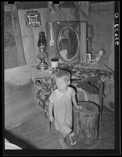 Untitled photo, possibly related to: Child of agricultural day laborer in front of dressing table in shack. Near Vian, Oklahoma