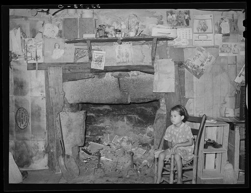 Indian child in front of mantelpiece in his home near Sallisaw, Oklahoma