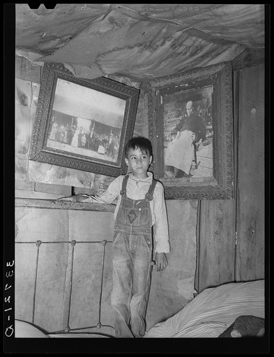 Indian boy between portraits of his ancestors. Near Sallisaw, Oklahoma