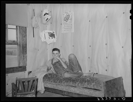 Son of woman tenant farmer on daybed in corner of living room near Sallisaw, Oklahoma