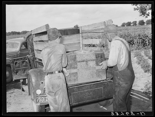 Placing the family chest into the rear of improvised truck which will take the Thomas family as migrants to California from Muskogee, Oklahoma