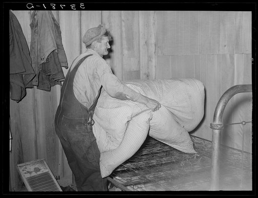Elmer Thomas removing the mattress from bed which will be packed into truck enroute for California. Near Muskogee, Oklahoma
