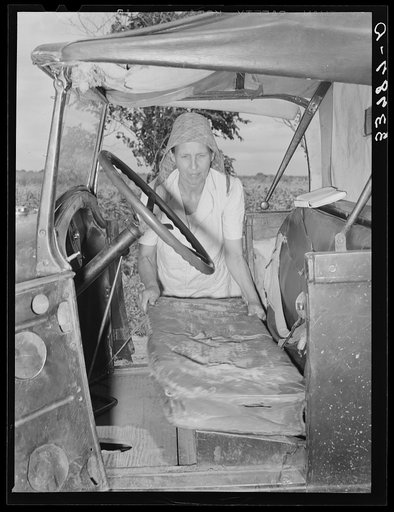 Mrs. Elmer Thomas, migrant to California, putting the front seat of their truck in place preparatory to departure from Muskogee, Oklahoma