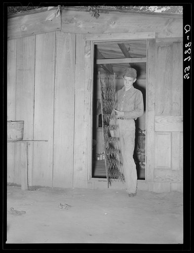 Untitled photo, possibly related to: Son of migrant family removing bed from home which will be packed into truck enroute for California. Near Muskogee, Oklahoma