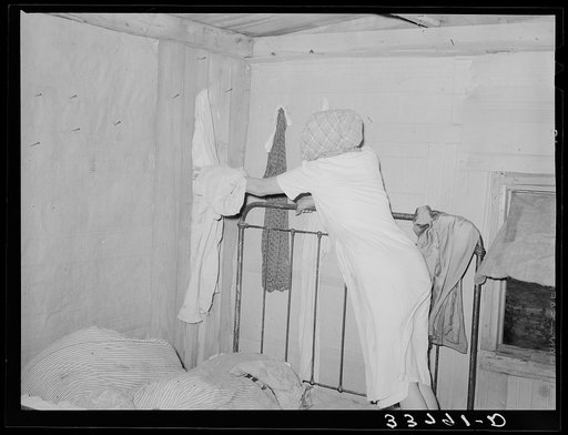 Interior of migrant's home near Muskogee, with mother removing articles of clothing preparatory for departure to California. Oklahoma