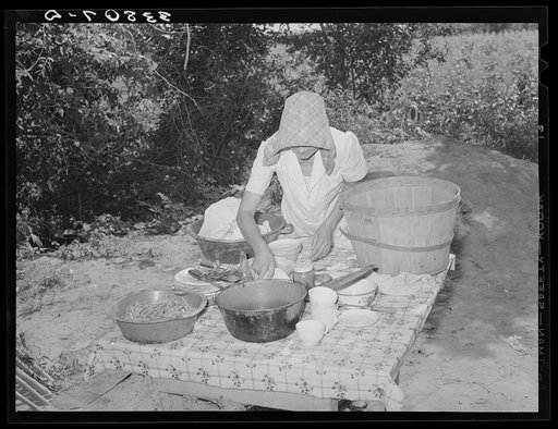 Packing dishes and silverware preparatory to departure for California from Muskogee, Oklahoma