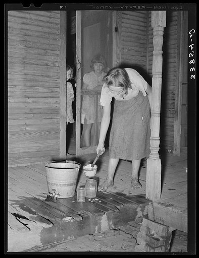 Daughter of tenant farmer near Muskogee, Oklahoma, changing water in goldfish bowl. Refer to general caption number 20