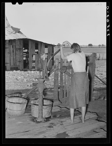 Daughter of tenant farmer living near Muskogee, Oklahoma, pumping water out of tub. See general caption number 20