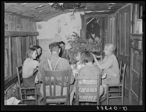 Family of tenant farmer at noonday meal near Muskogee, Oklahoma. His wife is shooing away flies with branch. See general caption number 20