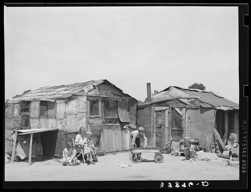 Family in front of shack home. Mays Avenue camp, Oklahoma City, Oklahoma. Refer to general caption 21