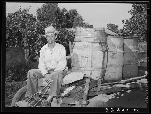 Untitled photo, possibly related to: Water peddler in community camp. Oklahoma City, Oklahoma. He is paid fifteen cents a barrel for delivering water to the shack homes