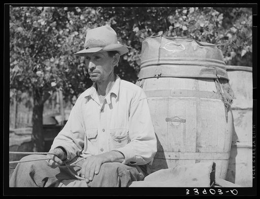 Water peddler in community camp. Oklahoma City, Oklahoma. He is paid fifteen cents a barrel for delivering water to the shack homes. See general caption no. 21