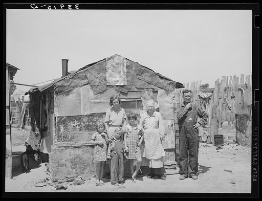 Family in front of shack home, Mays Avenue camp. Oklahoma City, Oklahoma. See general caption no. 21